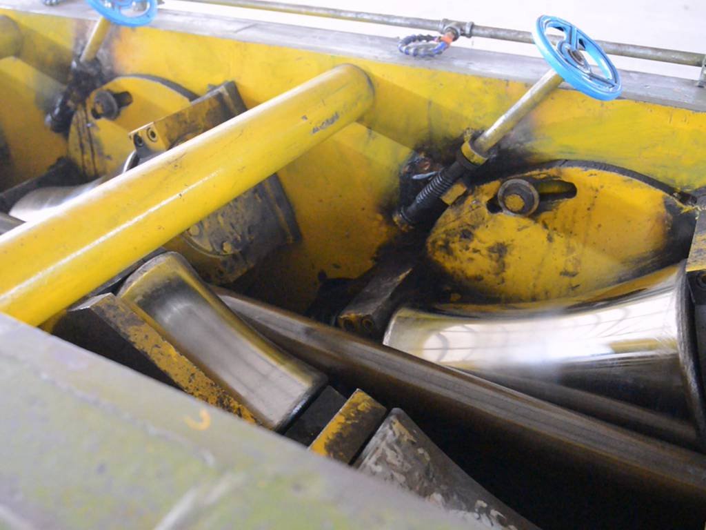 Máquina de endireitamento com vários rolos alinhando tubos de aço na HEVO STEEL LLC