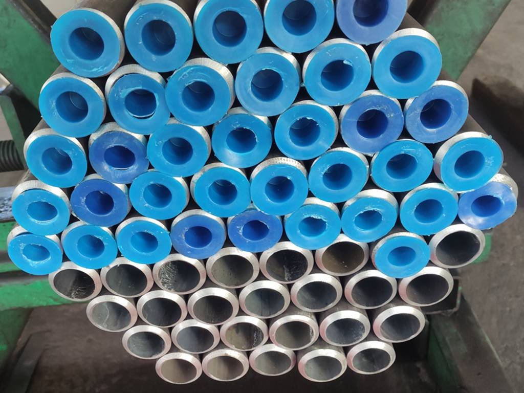 Plastic caps on ends of seamless steel tubes at HEVO STEEL