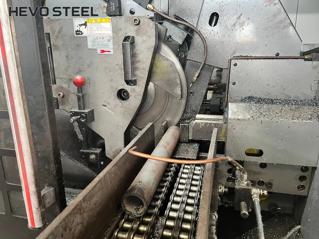 Round tube positioned at a saw blade on a chain feed bed.