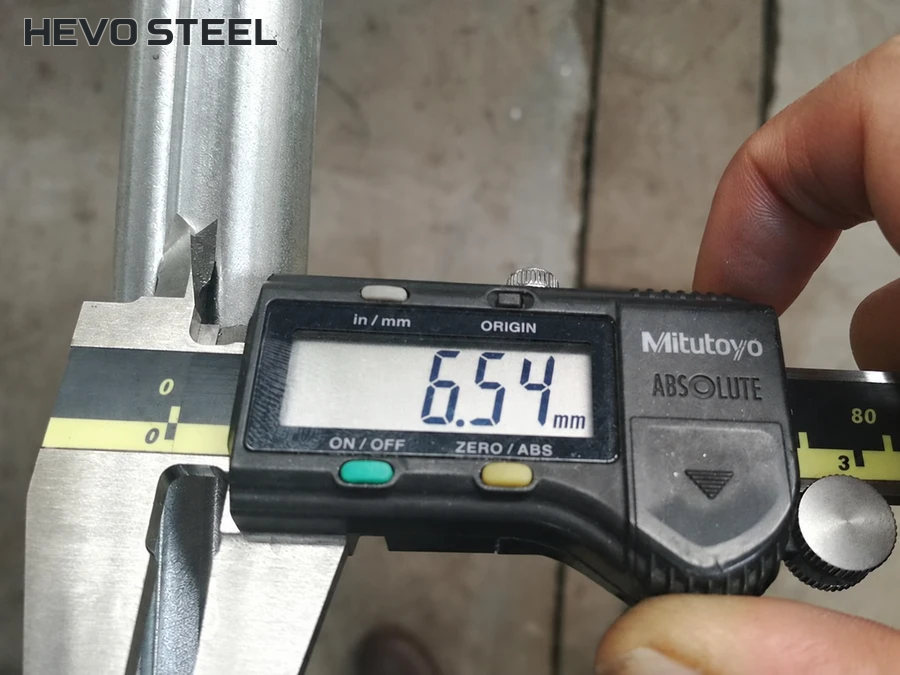Digital caliper positioned at a longitudinal groove opening.